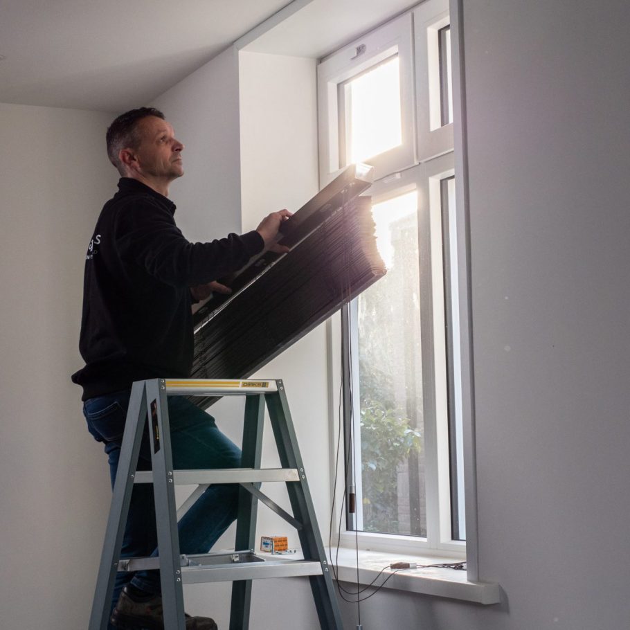 Twan hangt raamdecoratie op bij klanten